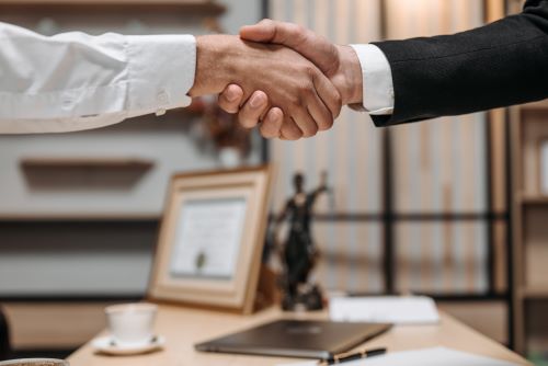 A lawyer shaking hands with a client.